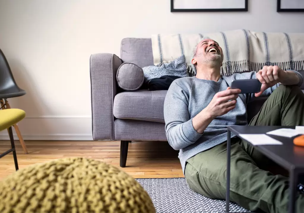 Oticon_Zircon_man_laughing_with_mobilephone_1024х717